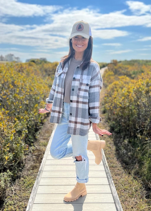 A reviewer styled in tan boots paired with jeans and a cozy flannel shirt.