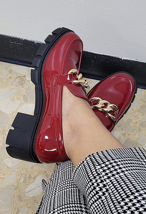 The reviewer shows off their red loafers, showcasing a bold fashion choice that stands out.