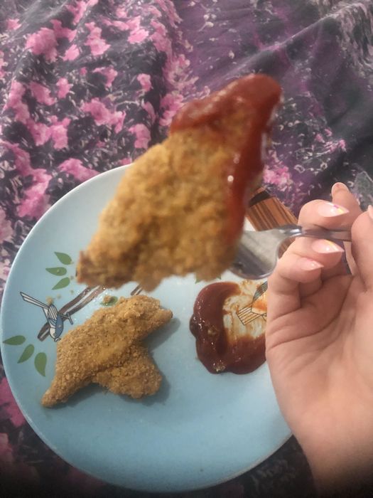 A chicken nugget topped with a generous dollop of hot sauce.