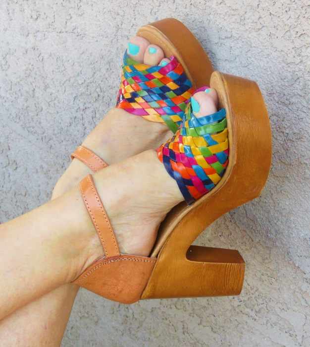 A model’s feet are seen wearing colorful wedges.