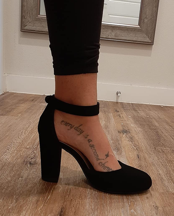 A reviewer’s foot is seen wearing black heels.