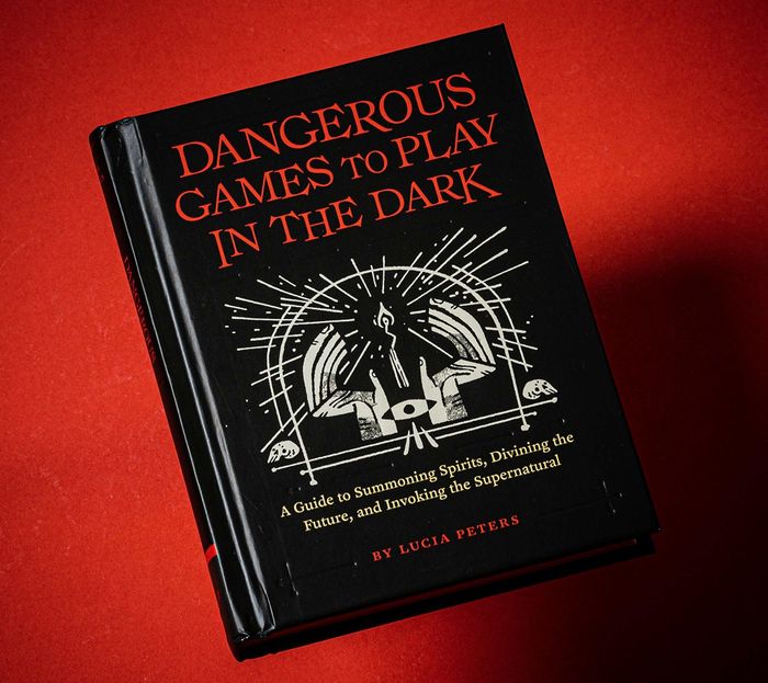 The book set against a dark red, shadowy backdrop.