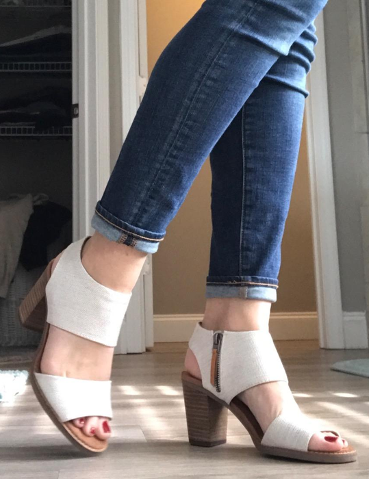 A side profile of a reviewer sporting white sandals.