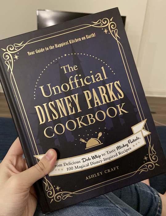 A customer review photo of the Unofficial Disney Parks Cookbook, showing its appealing design and content