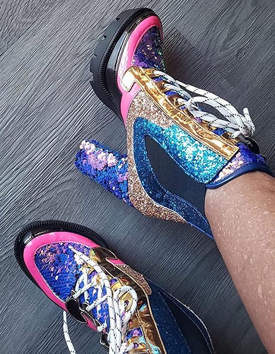 A reviewer’s feet are seen wearing multicolored sequined boots.
