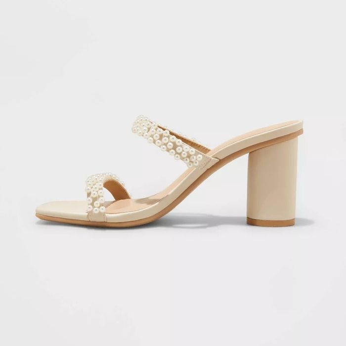 A pearl-adorned heeled sandal set against a clean white backdrop, perfect for adding an elegant touch to your wardrobe.