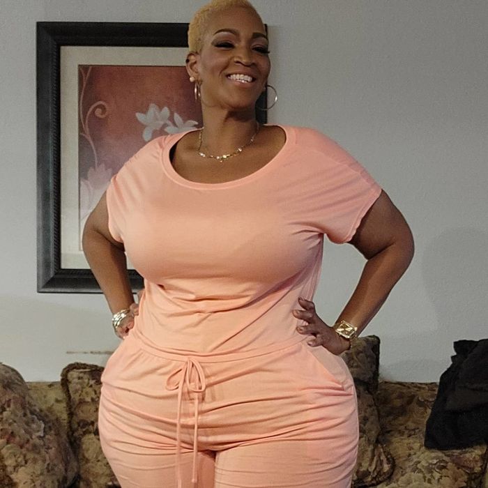 The reviewer is styled in a chic pink jumpsuit.