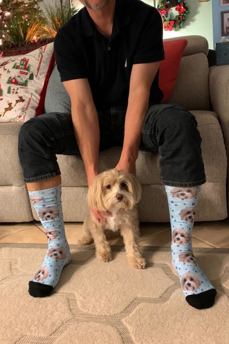A reviewer proudly wearing socks featuring their dog's face