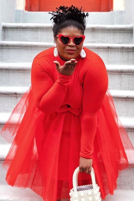A reviewer wearing red heart-shaped sunglasses