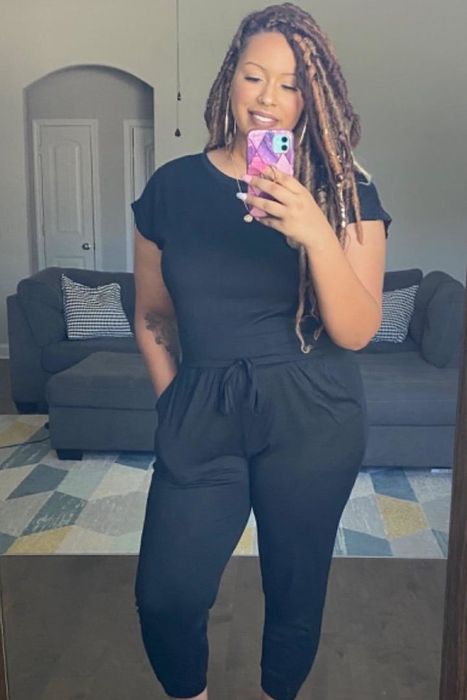 The reviewer is dressed in a sophisticated black jumpsuit.