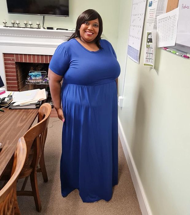 The reviewer is wearing a beautiful blue dress.