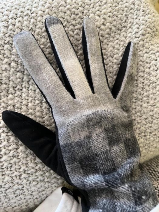 A reviewer wearing one of the gloves in white, gray, and black