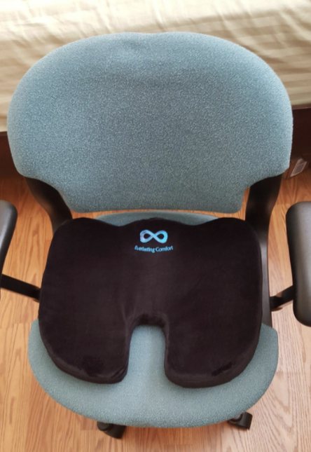 The cushion placed on a computer chair, adding comfort to long hours of sitting.