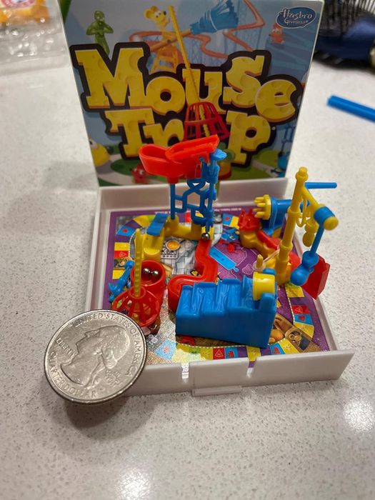 The miniature Mouse Trap game set up next to a quarter for a size comparison