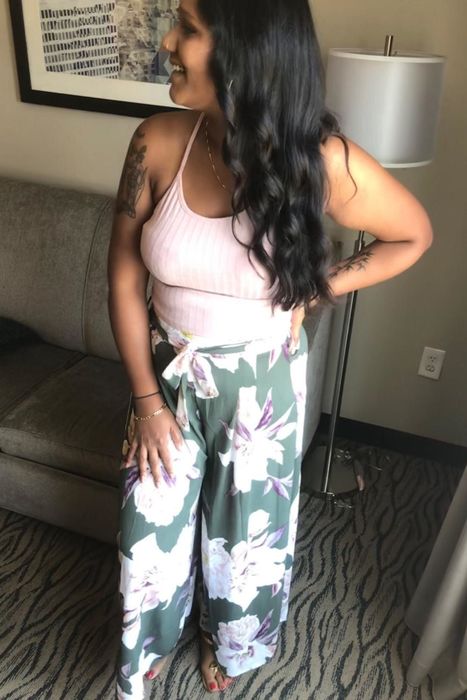 A reviewer is wearing floral wide-leg pants.