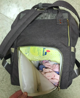 A reviewer’s photo showcasing the storage compartments in the diaper bag, highlighting how spacious and organized it is.