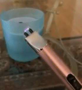 A GIF showing a reviewer lighting a candle with the pink electric lighter