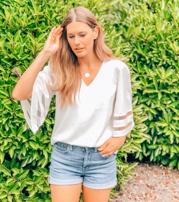 The reviewer is seen wearing a pristine white top.