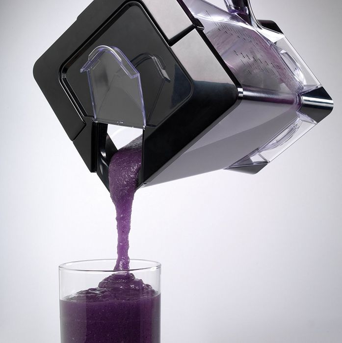 Pouring a smoothie from the blender’s opening at the top, making it easy to serve.