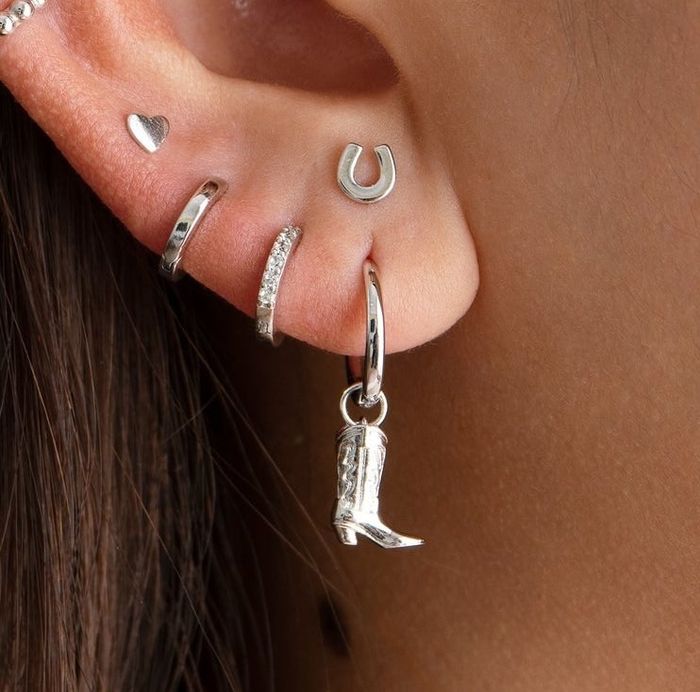 A small hoop earring featuring a charming boot pendant.