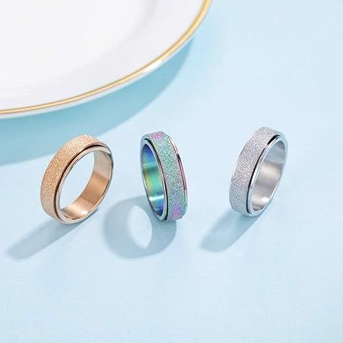 Three styles of the fidget ring: gold, rainbow, and silver.