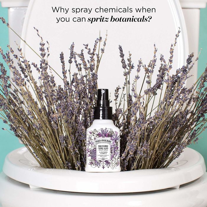 A bottle of Poo-Pourri placed in a toilet, surrounded by sprigs of lavender, adding a touch of natural fragrance.
