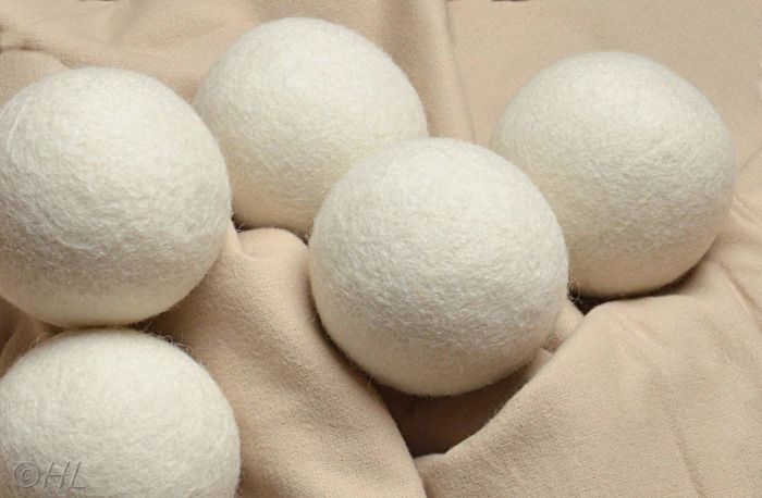 The wool dryer balls are seen resting on a blanket, ready to help reduce drying time and static.