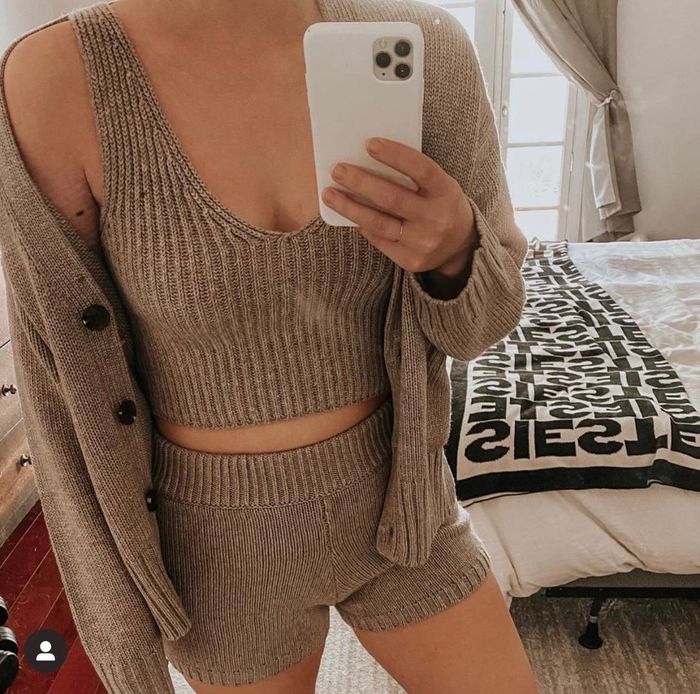 The reviewer is wearing a tan-colored knitwear set.