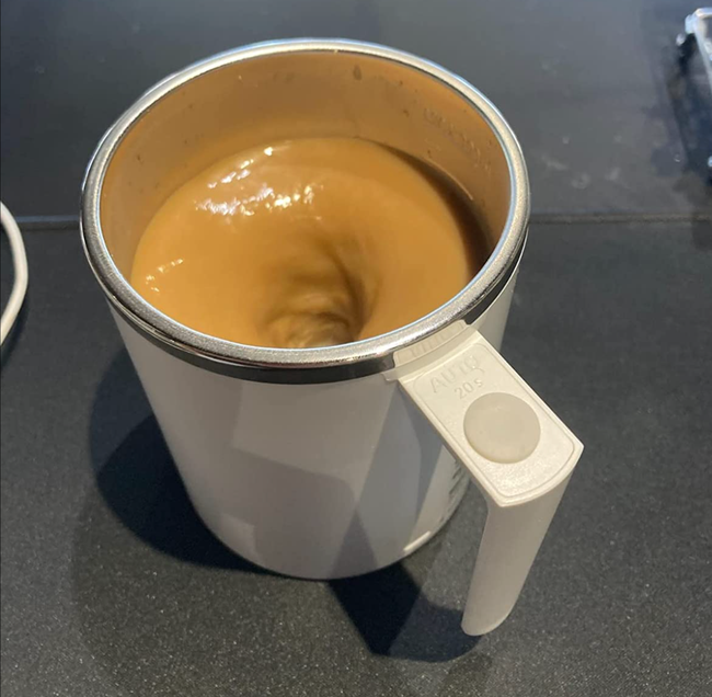 A reviewer's photo of a white mug with swirling coffee inside, creating a mesmerizing blend.