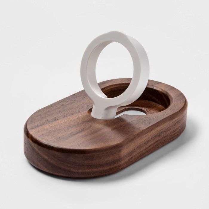 The stand, which features an oval-shaped wooden base, with a round holder that pops out to hold the Apple Watch.
