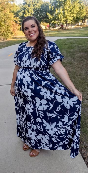 A reviewer in the white and navy floral maxi dress