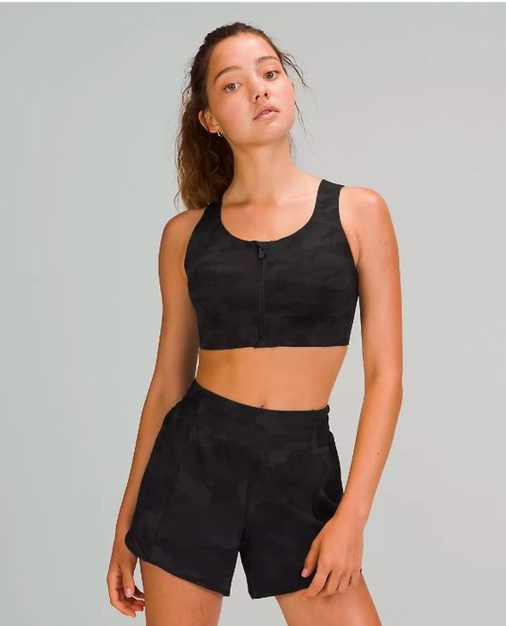 A model wearing the black camo sports bra
