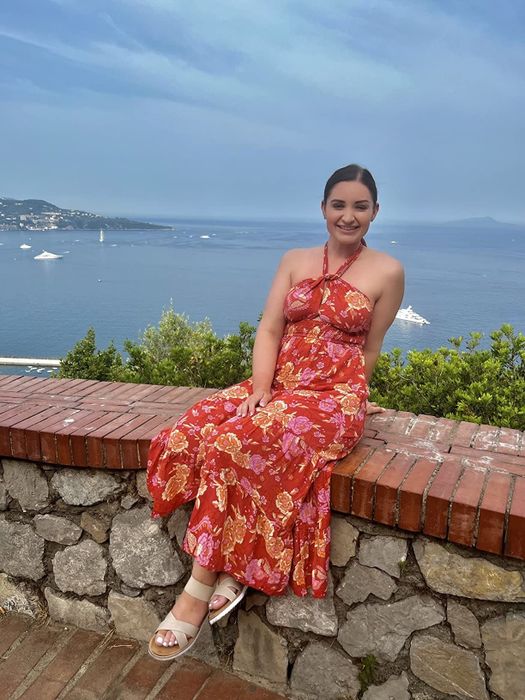 A reviewer wearing the red floral dress