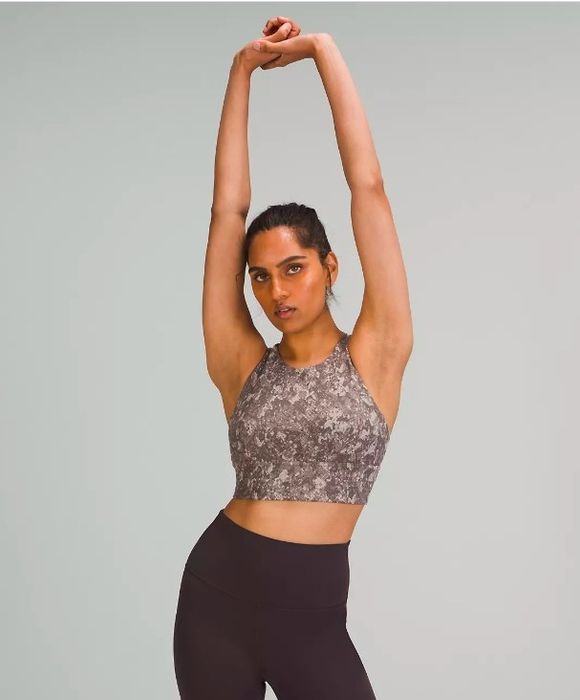 A model demonstrating a stretch in the pink camo bra