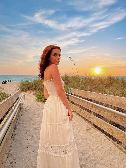 A reviewer wearing the white maxi dress
