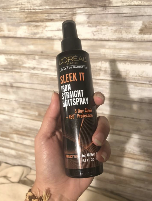 a reviewer holding a bottle of spray in their hand