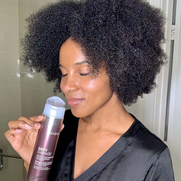 a person holding the shampoo bottle