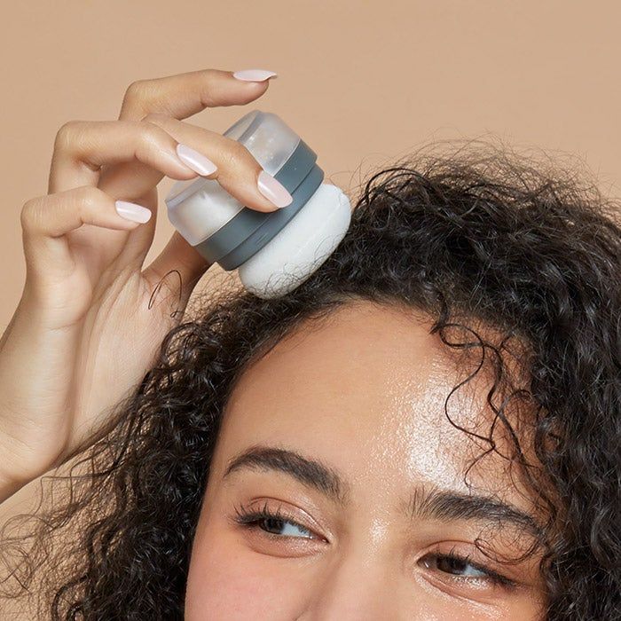 a model applying powder to the roots of their hair