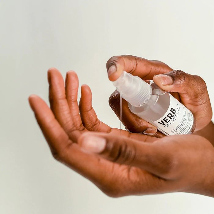 model dispensing the oil into their hand