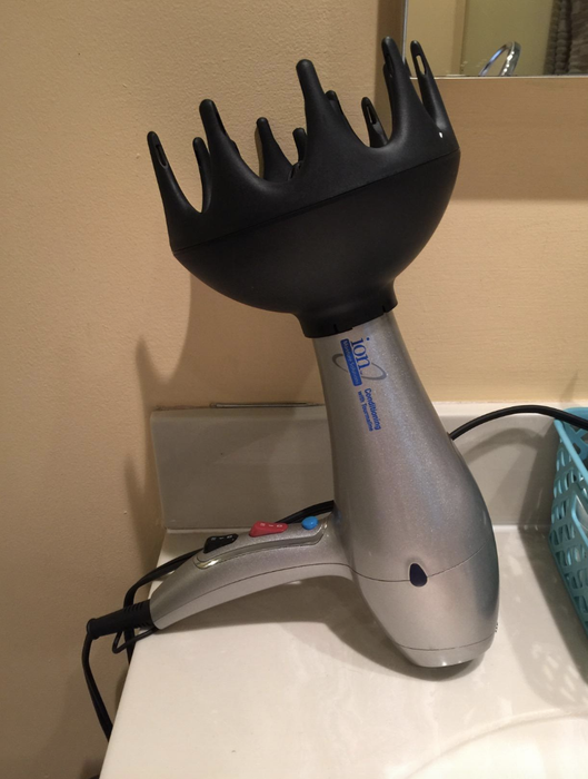The black, wide diffuser attachment attached to a standard hair dryer