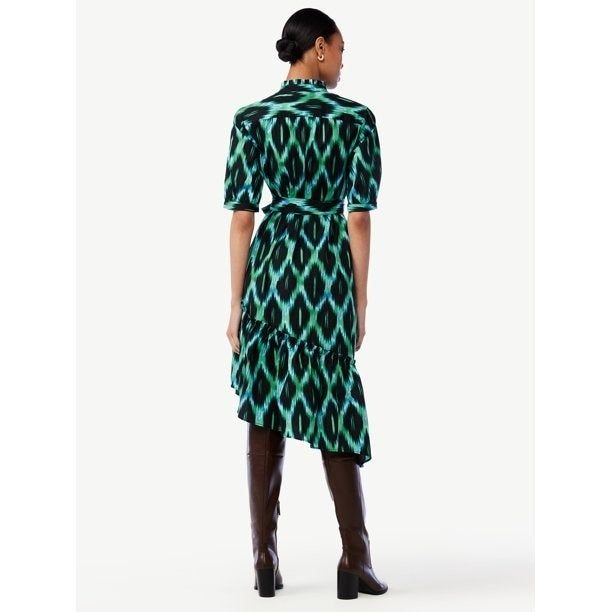 The model is wearing the dress paired with tall boots.