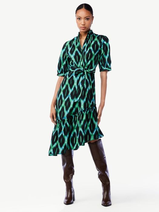 The model is wearing the dress paired with tall boots.