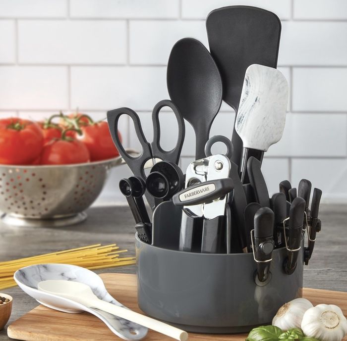 The black, stainless steel, and marble toolset is neatly arranged on a countertop surrounded by pasta-making ingredients.