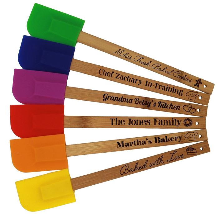A set of six personalized spatulas, each one uniquely designed with custom fonts, icons, and colors.