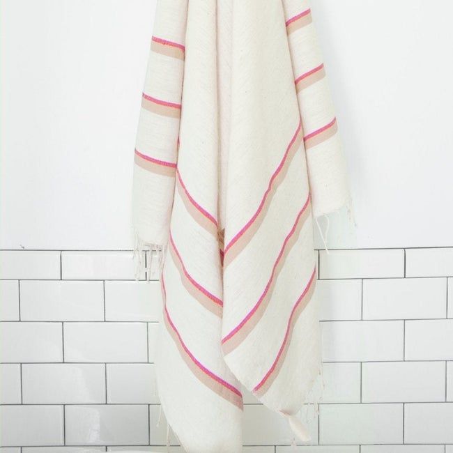 A white towel featuring elegant blue and beige stripes.