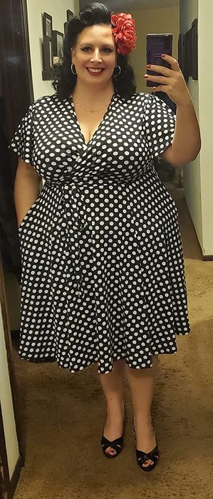 A reviewer styling the dress in black with white polka dots.