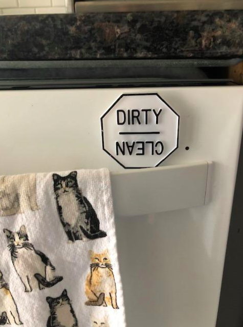 The magnet placed on the dishwasher with the 'dirty' side facing up.