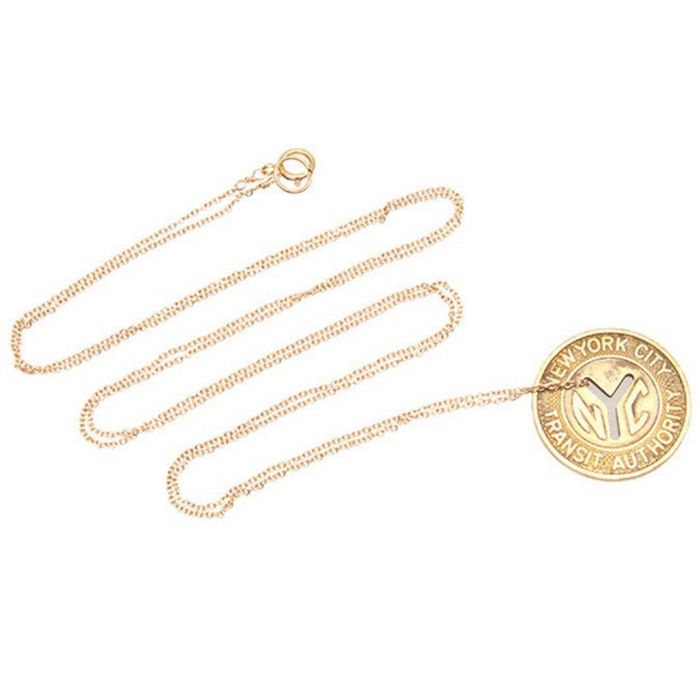 A gold chain featuring a genuine NYC subway token, adding a touch of nostalgia and urban charm to your jewelry collection.