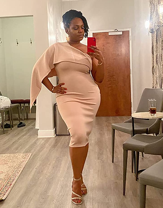 A reviewer wearing the dress in a soft light pink shade.