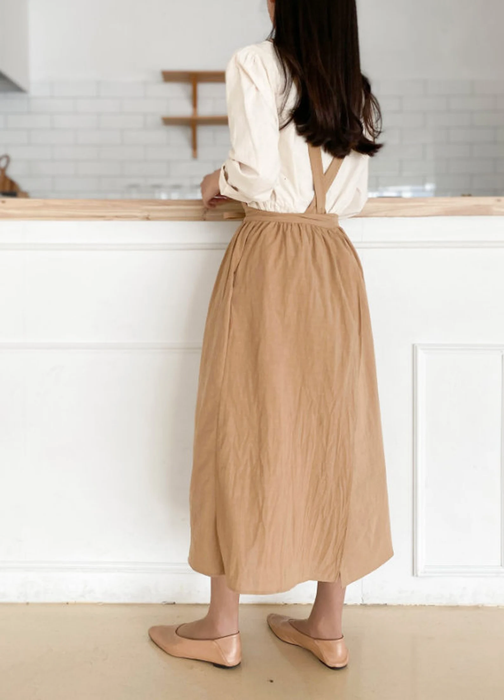 Model showcasing the crossed-back straps of the apron